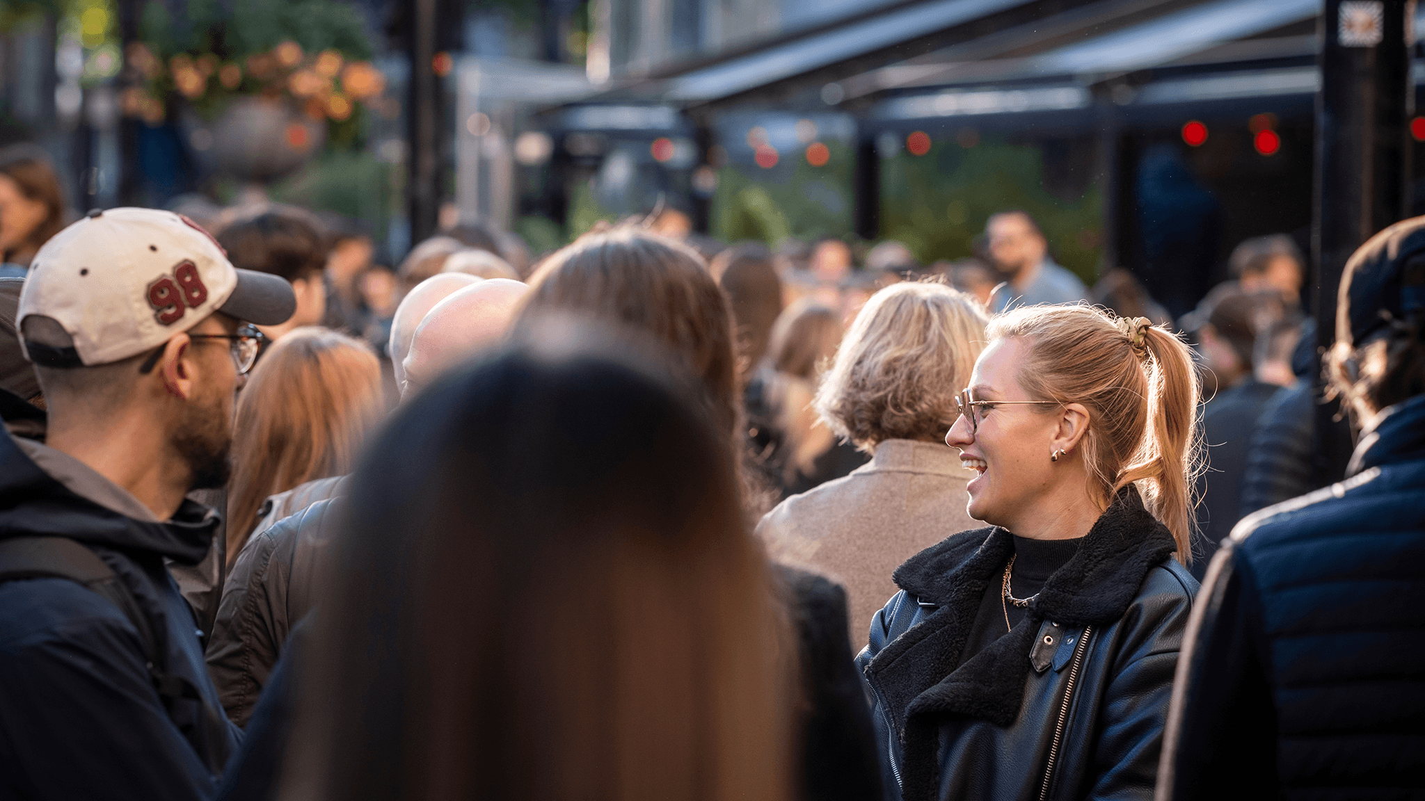 A smiling attendee in a crowd outside Chinateatern at EICON25.