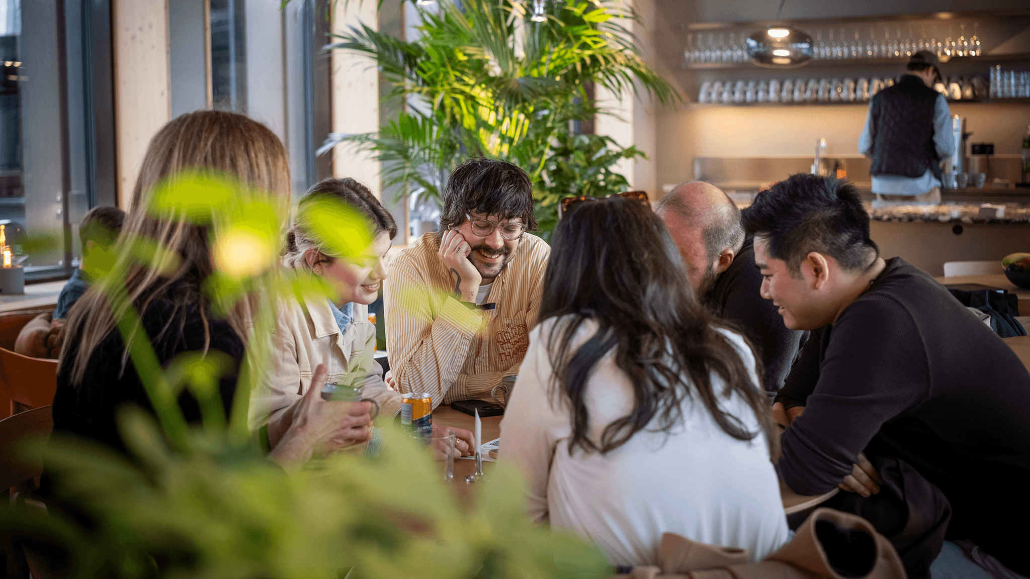 Team members socialising in Eidra's plant-filled office lounge.